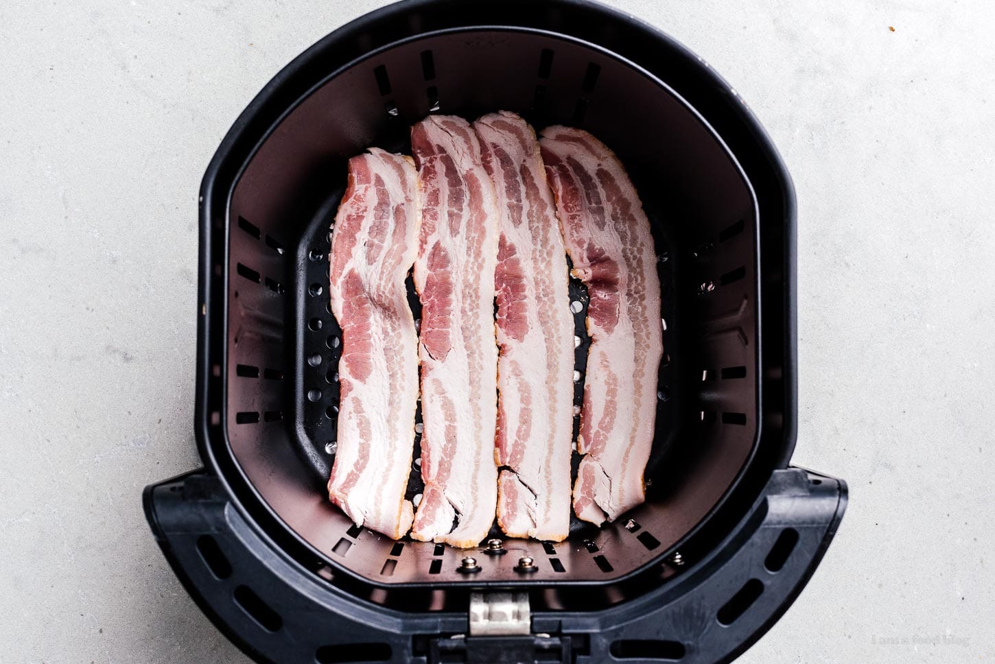 bacon in an air fryer basket | www.iamafoodblog.com
